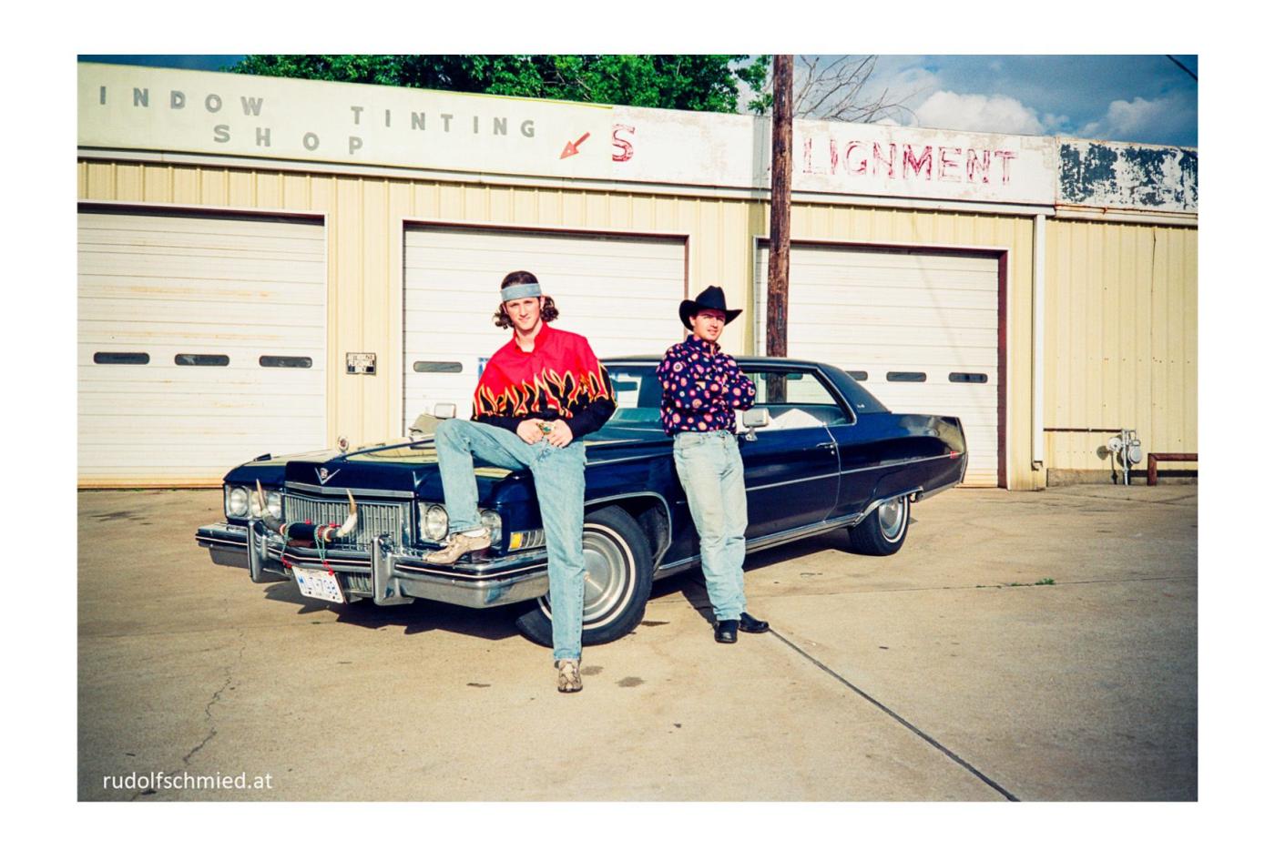 Zweit Cowboys vor einem Cadillac Coup de Ville 1973