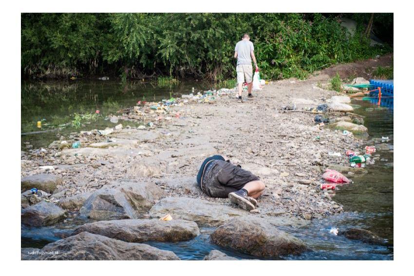Ein betrunkener Musikfan liegt am Rande eines Flusses