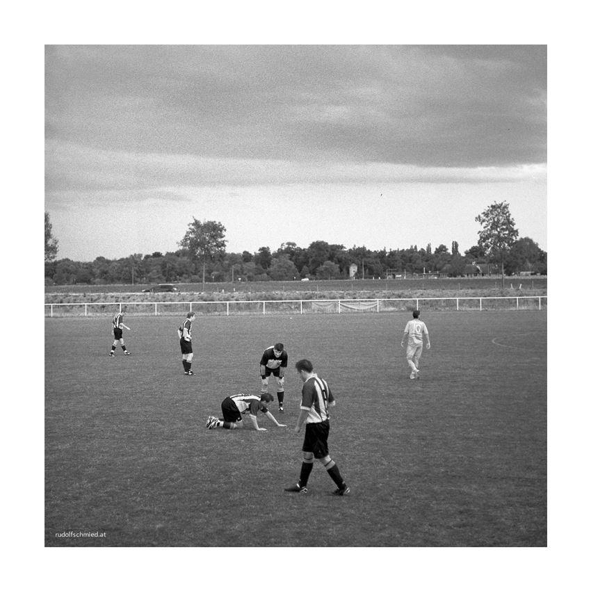 Ein Fußballer sucht seine Kontaktlinse auf dem Spielfeld