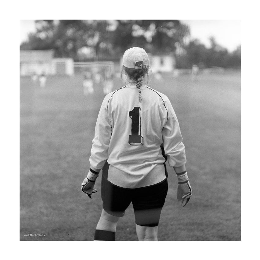EIne Torfrau beobachtet ein Fußballspiel