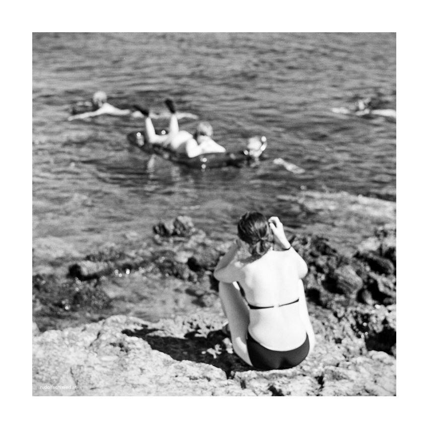 Eine Frau fotografiert ihre Kinder im Meer