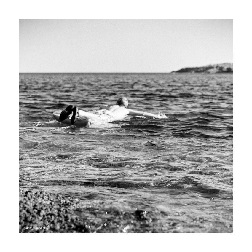Ein Mann auf einer Luftmatratze im Meer