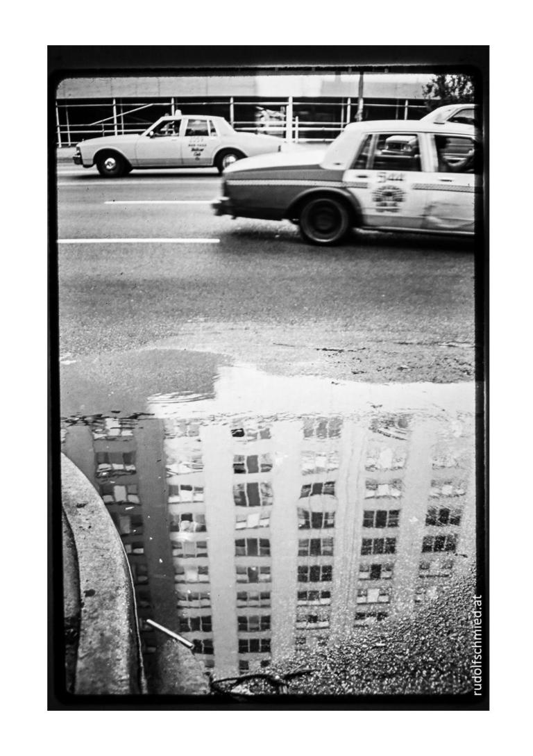 Eine Spiegelung eines Wolkenkratzers und ein Taxi in Chicago